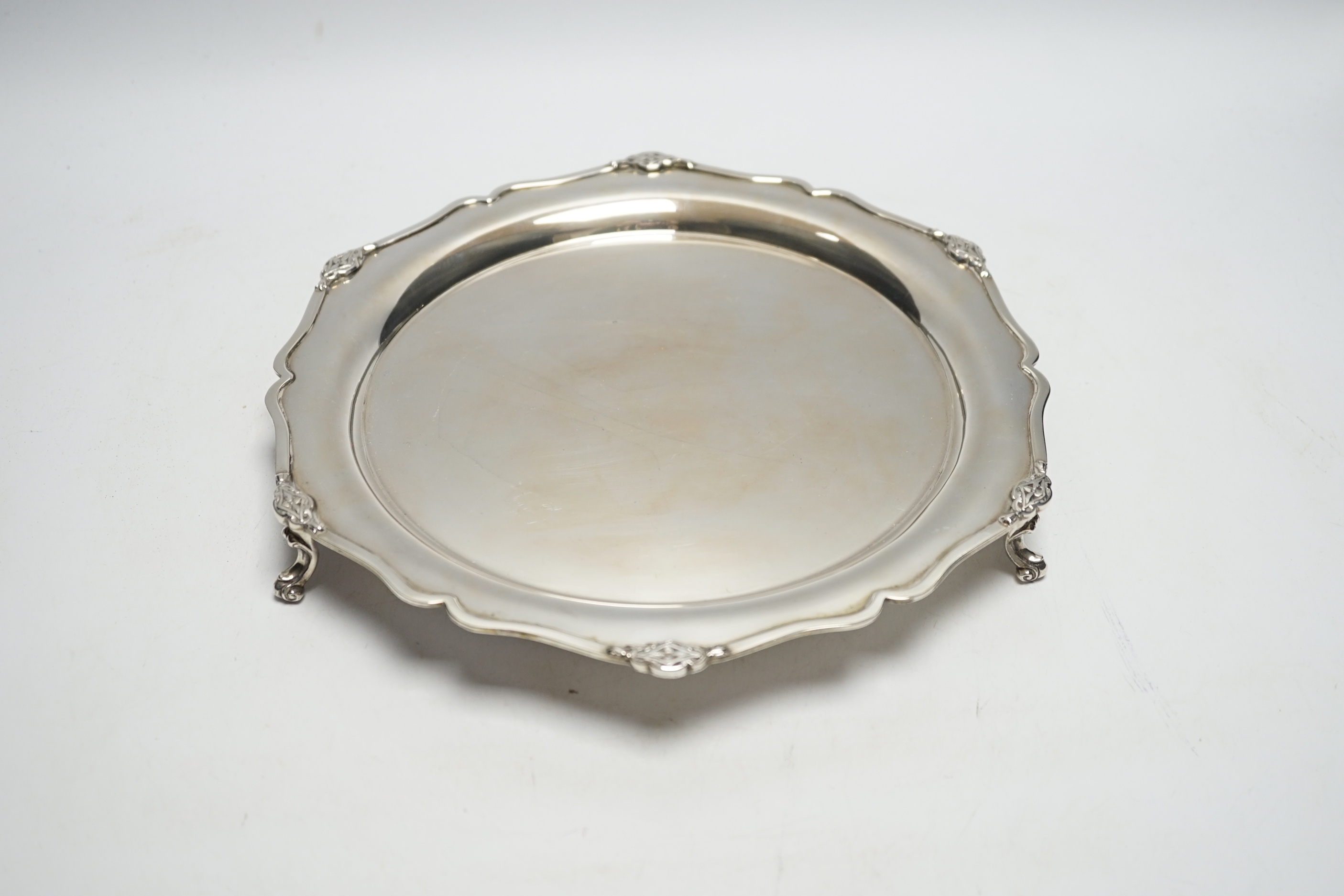 A George V silver shaped circular salver, on three scroll feet, Martin, Hall & Co, Sheffield, 1929, 26.9cm, 17.2oz.